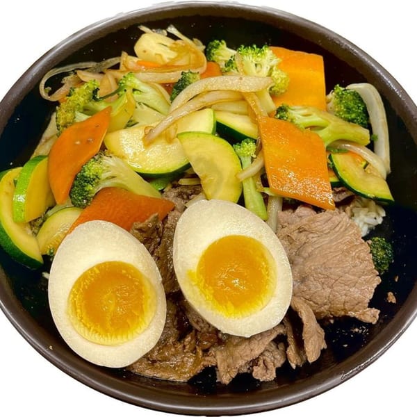 Madden Ramen bowl with sliced beef, mixed vegetables, and two soft-boiled eggs.